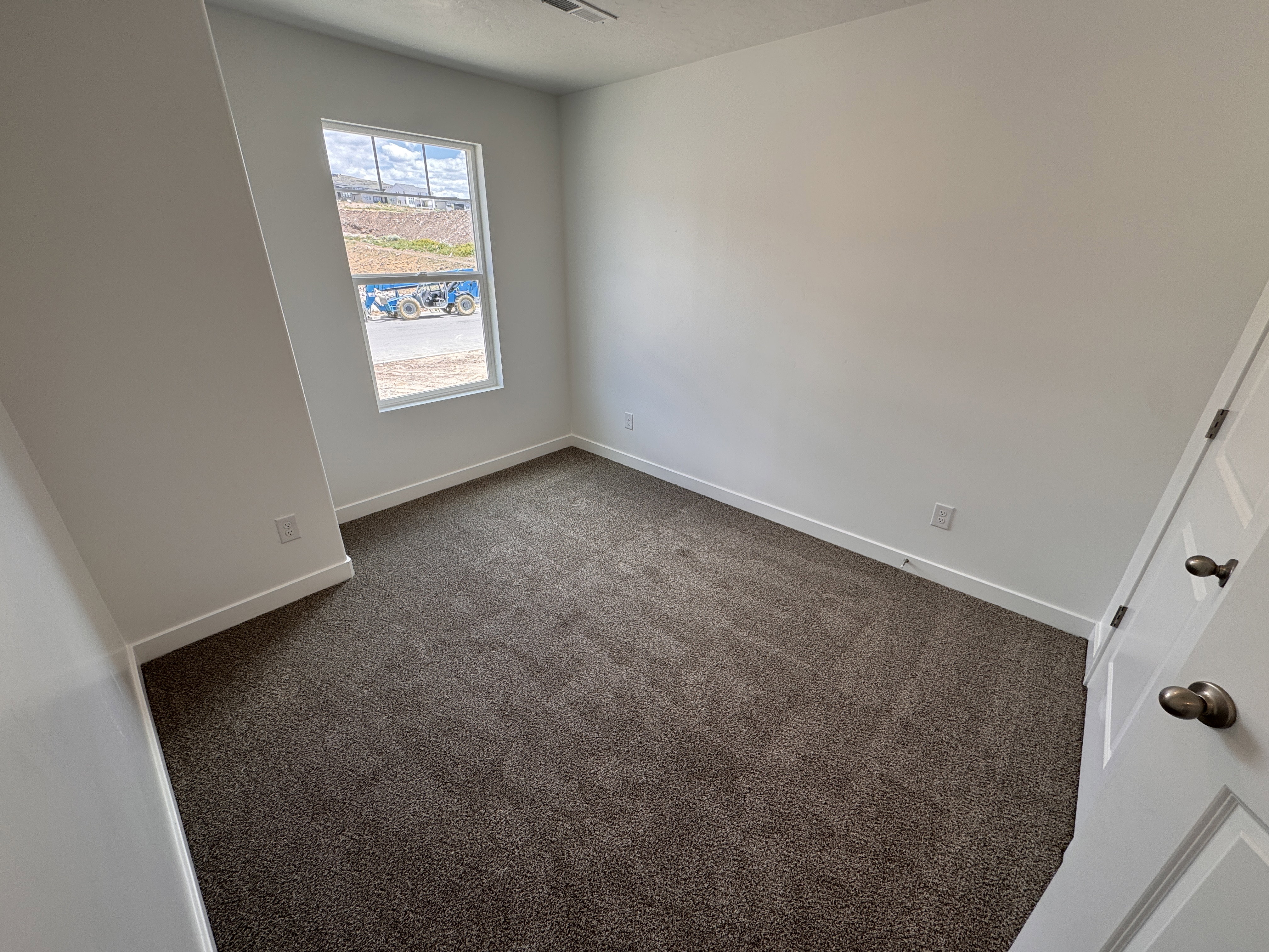 Carpeted interior space featuring a window with white trim, white walls, and white baseboards