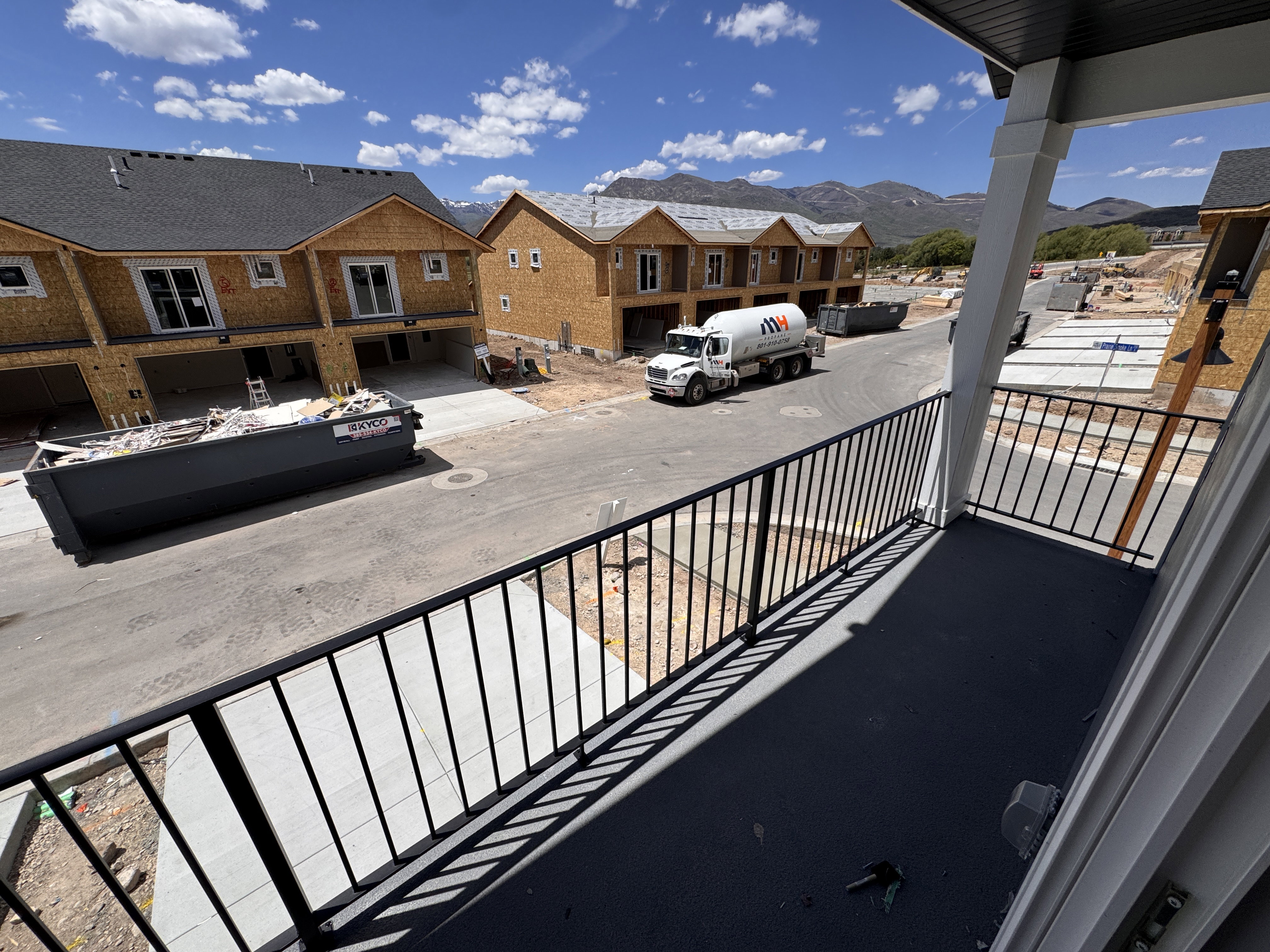 Balcony with black metal railings and painted concrete flooring