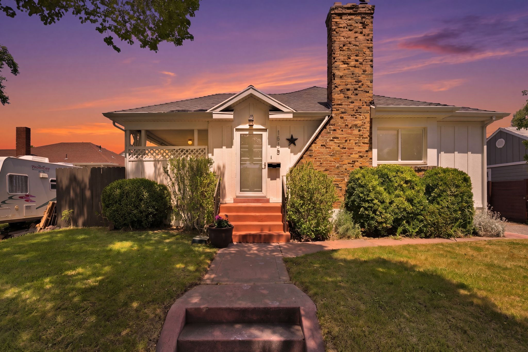 Single-story residence featuring a brick chimney, white siding, and a covered front porch