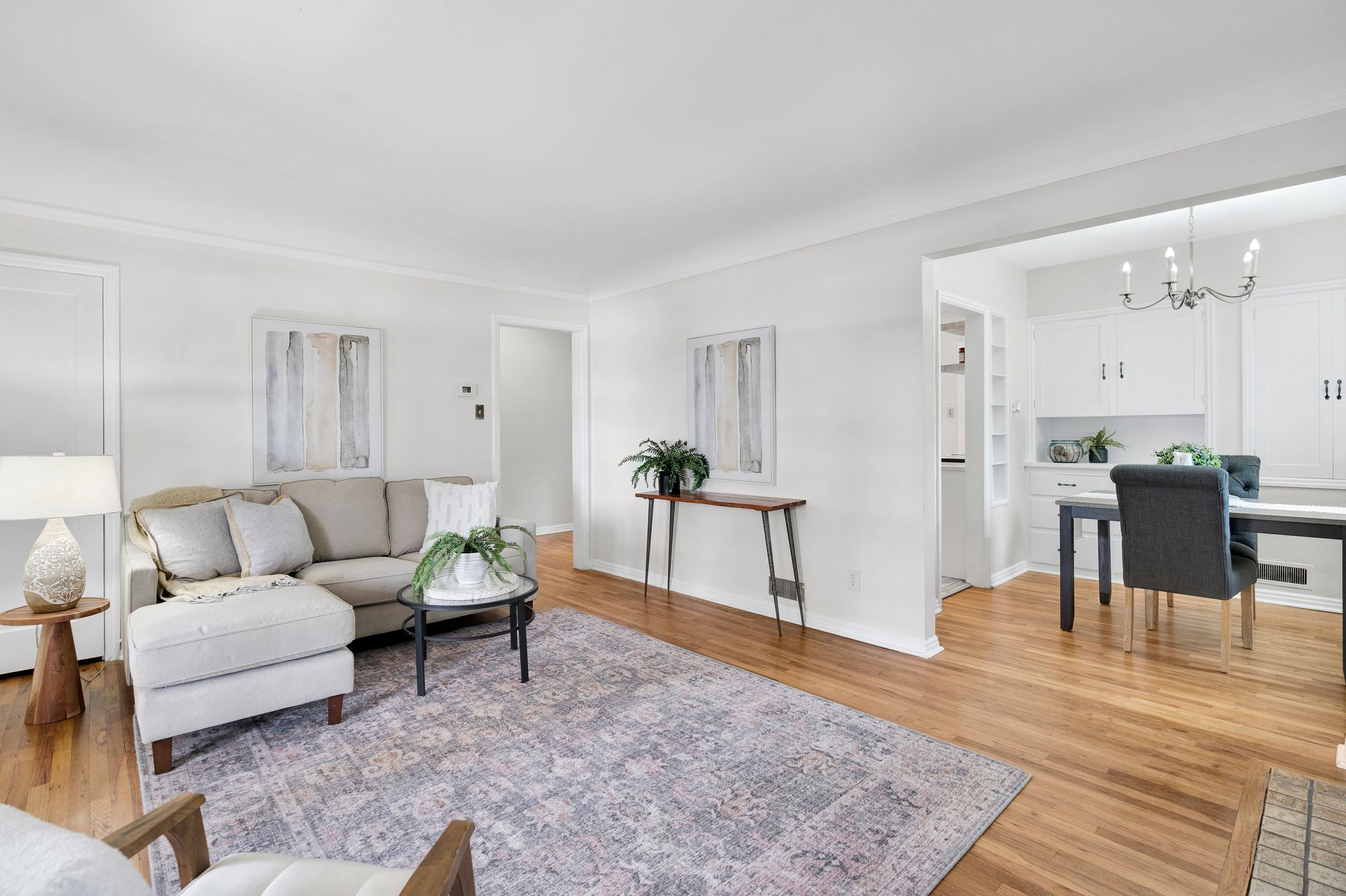 Hardwood flooring extends throughout this living area, featuring white walls and white trim