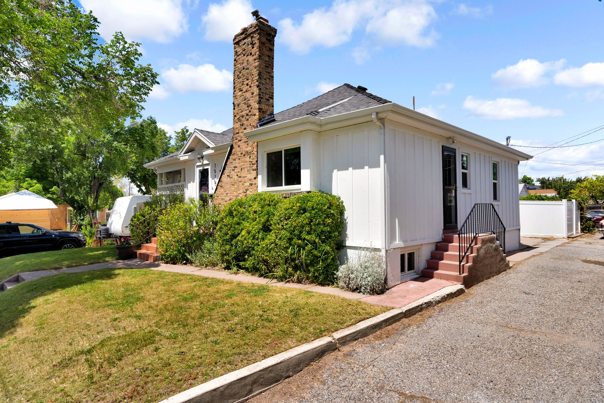 White siding exterior with a prominent brick chimney