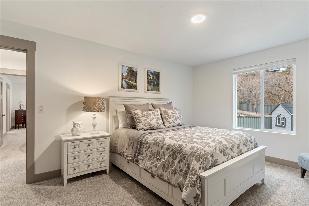 Spacious room featuring neutral carpeting, a large window, recessed lighting, and a doorway with contrasting trim