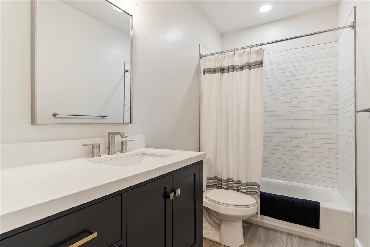Bathroom featuring a dark vanity with a white countertop, under-mount sink, and brushed nickel fixtures