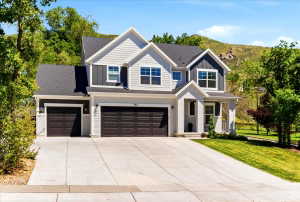 Contemporary two-story residence featuring light gray siding and dark gray vertical accents
