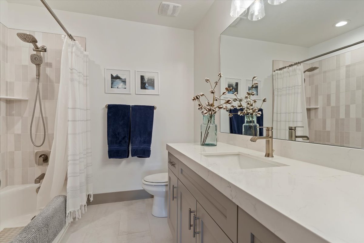 Bathroom featuring a light gray vanity with brushed nickel hardware, a white countertop, and an integrated rectangular sink