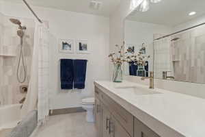Bathroom featuring a light gray vanity with brushed nickel hardware, a white countertop, and an integrated rectangular sink
