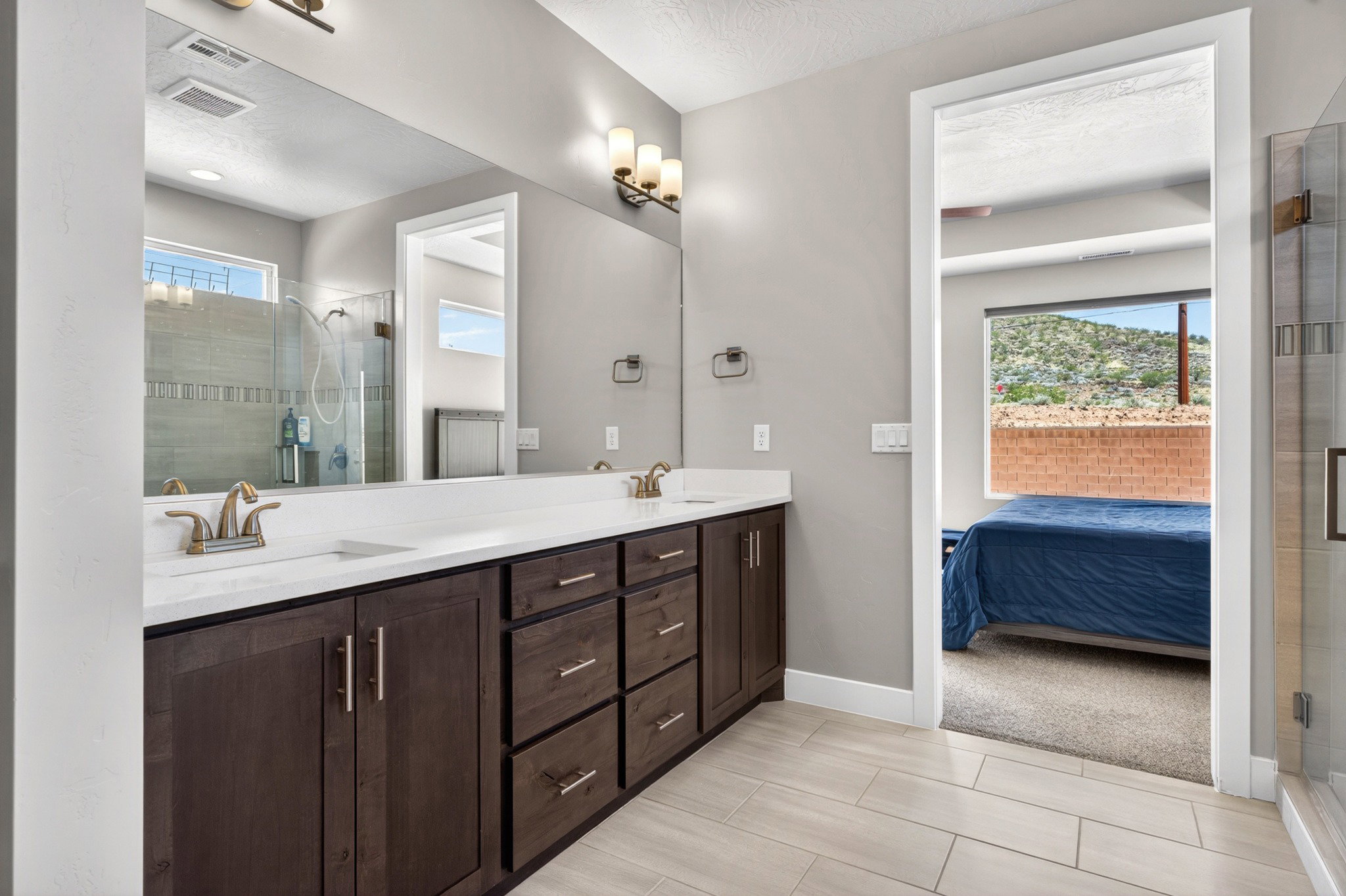 Dual vanity with white countertops and dark wood-finish cabinetry