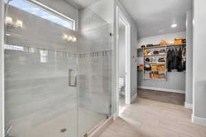 Walk-in shower with clear glass enclosure and light-toned tilework
