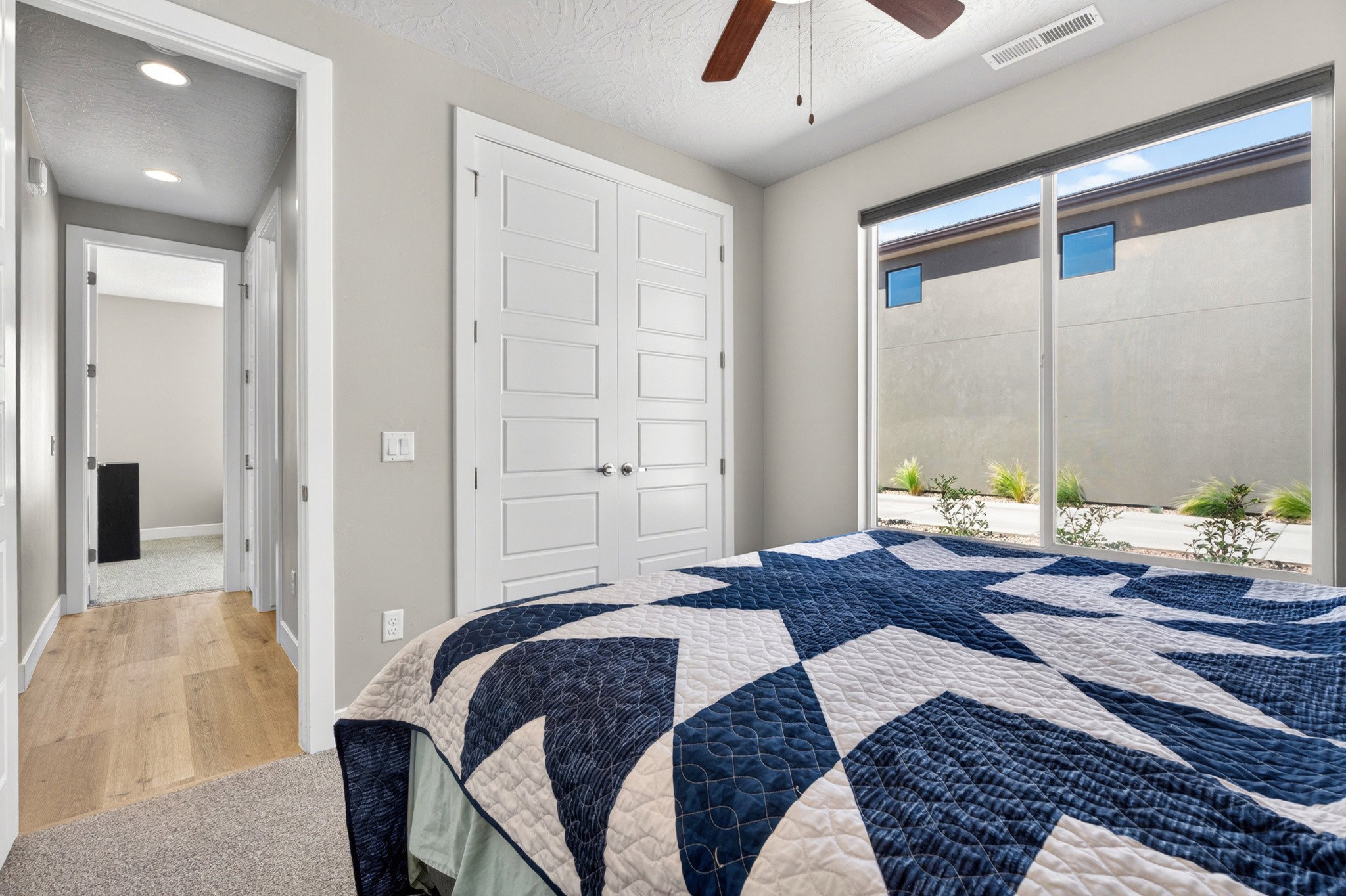 Bedroom featuring a large window, contemporary ceiling fan, and carpet flooring