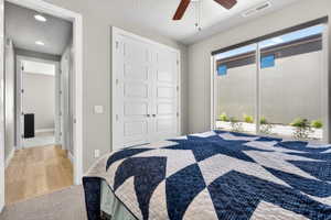 Bedroom featuring a large window, contemporary ceiling fan, and carpet flooring