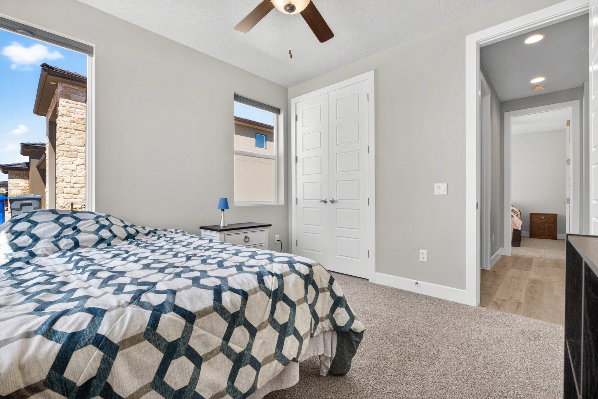 Bedroom featuring light gray walls, carpet flooring, a ceiling fan, and white panel doors