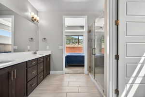 Dual sink vanity with dark wood-finish cabinetry, light countertops, and brushed nickel hardware