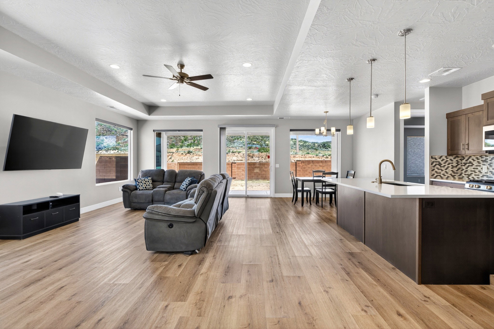 Open-concept living space featuring wood-finish flooring, recessed lighting, and a ceiling fan