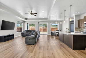 Open-concept living space featuring wood-finish flooring, recessed lighting, and a ceiling fan