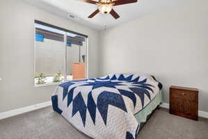 Carpeted room featuring a large window, a ceiling fan with integrated lighting, and neutral wall paint