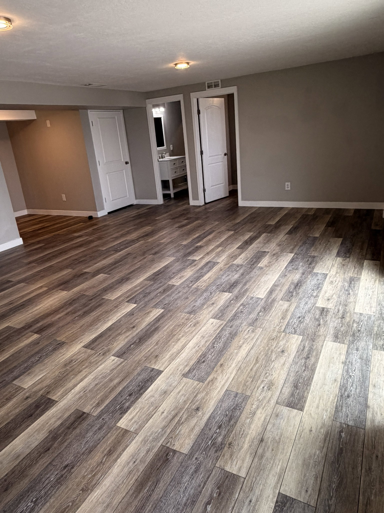 Spacious room featuring wood-finish flooring, neutral-toned walls, and recessed lighting