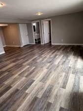 Spacious room featuring wood-finish flooring, neutral-toned walls, and recessed lighting