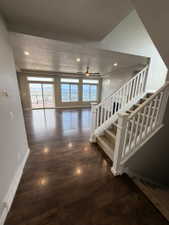 Open living area with wood-finish flooring and extensive window line