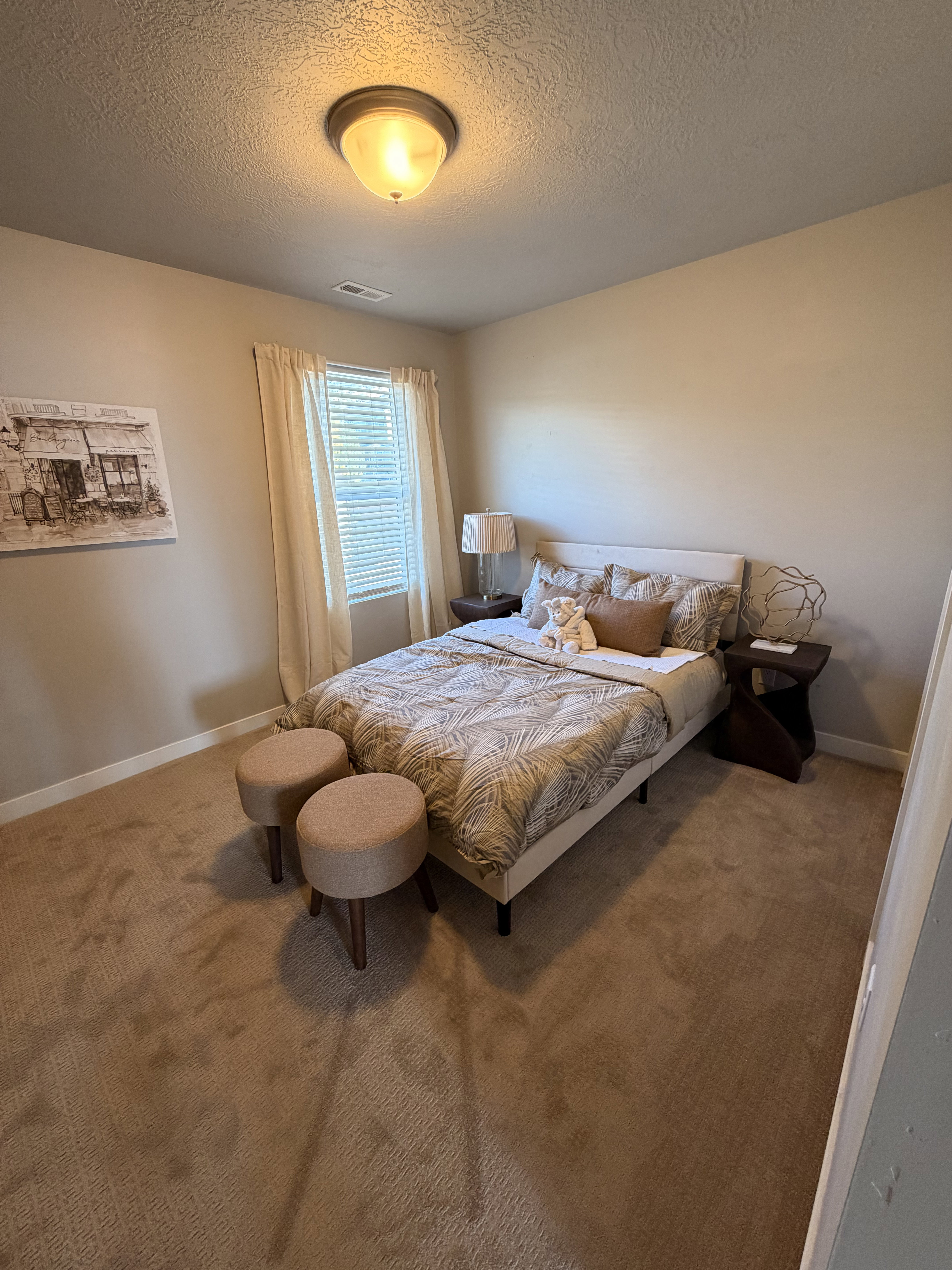Neutral tone wall paint, textured ceiling, and light-filtering window treatments