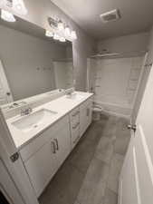Dual vanity featuring white cabinetry, light-toned countertops, and chrome fixtures