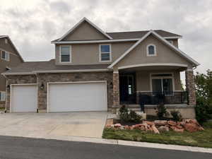 Two-story residence featuring a stucco and stone veneer exterior