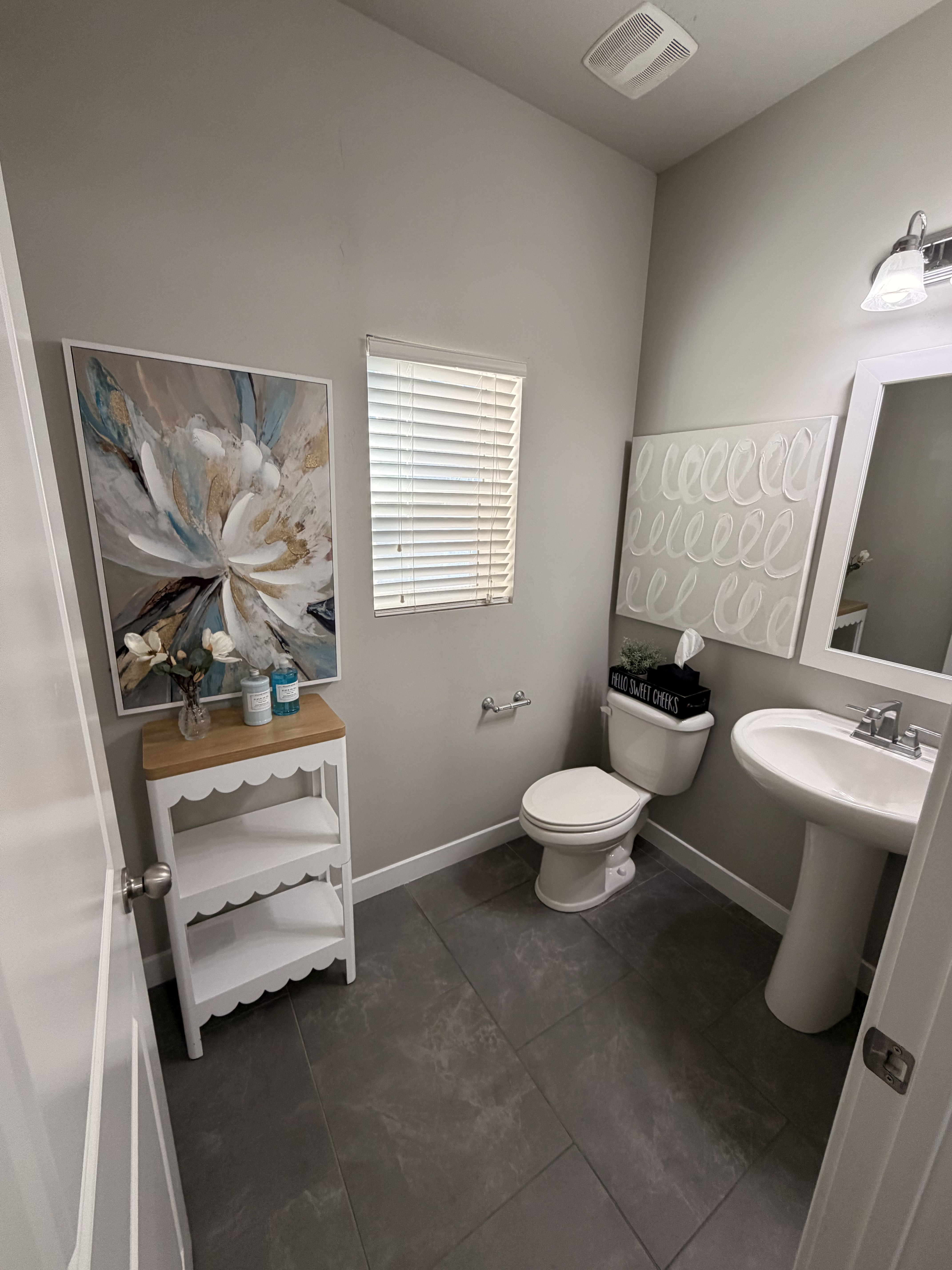 Bathroom featuring dark tile flooring, a pedestal sink, and a window with blinds