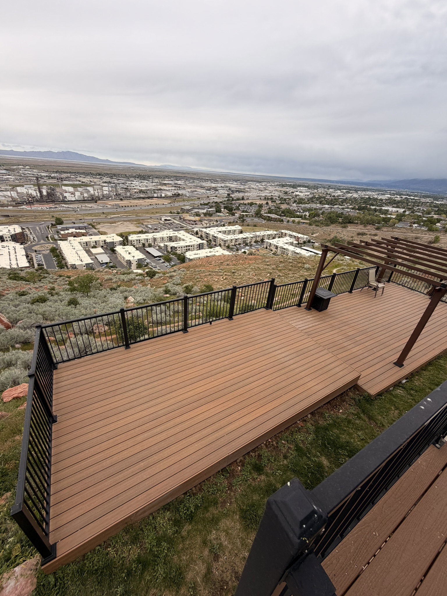 Expansive outdoor deck featuring wood-finish composite decking and black metal railings