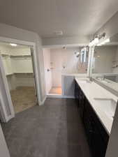 Modern bathroom featuring a dual vanity with light-toned countertops and dark cabinetry