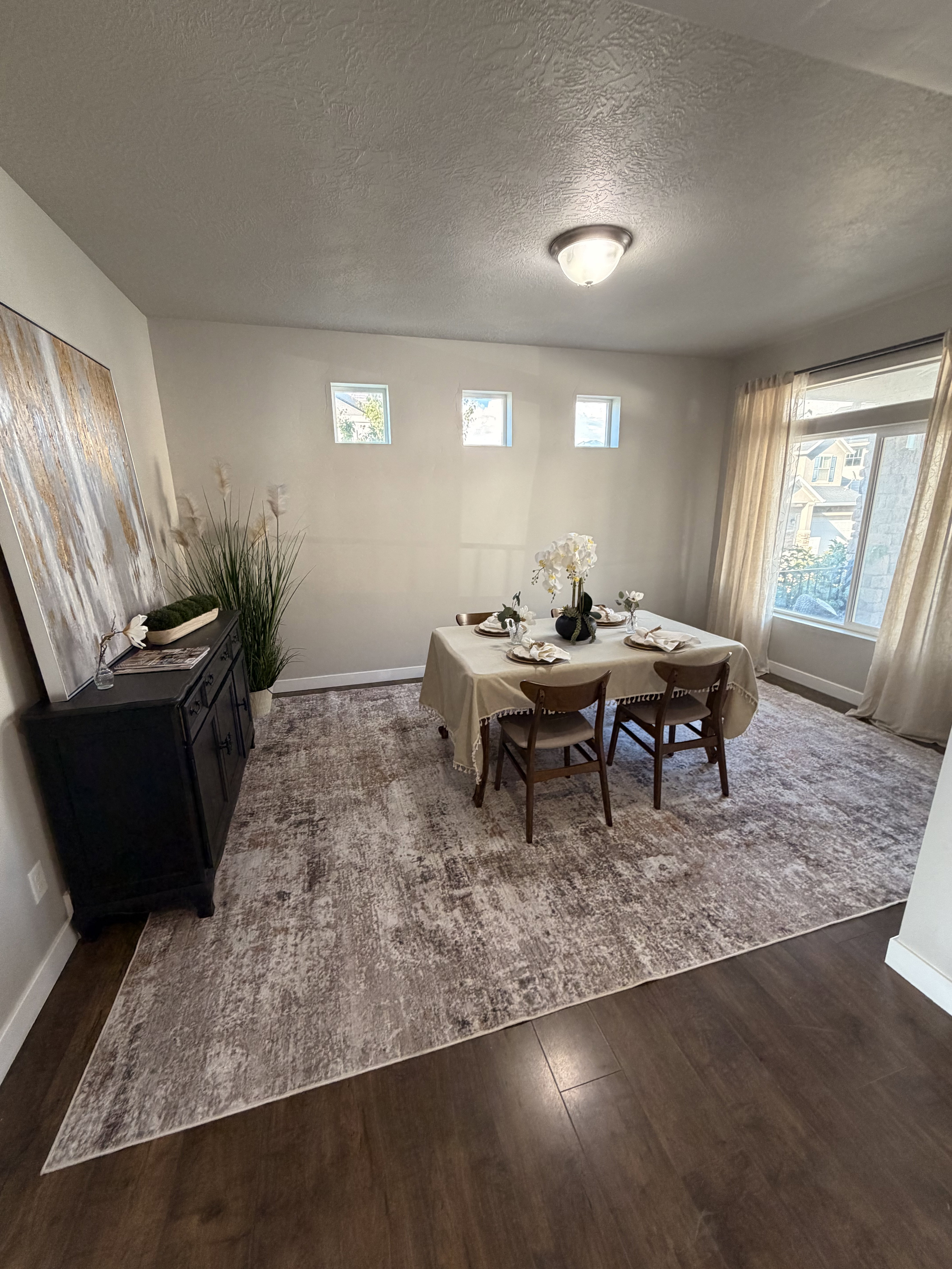 Formal dining area featuring rich wood-finish flooring, a large area rug, and recessed wall windows