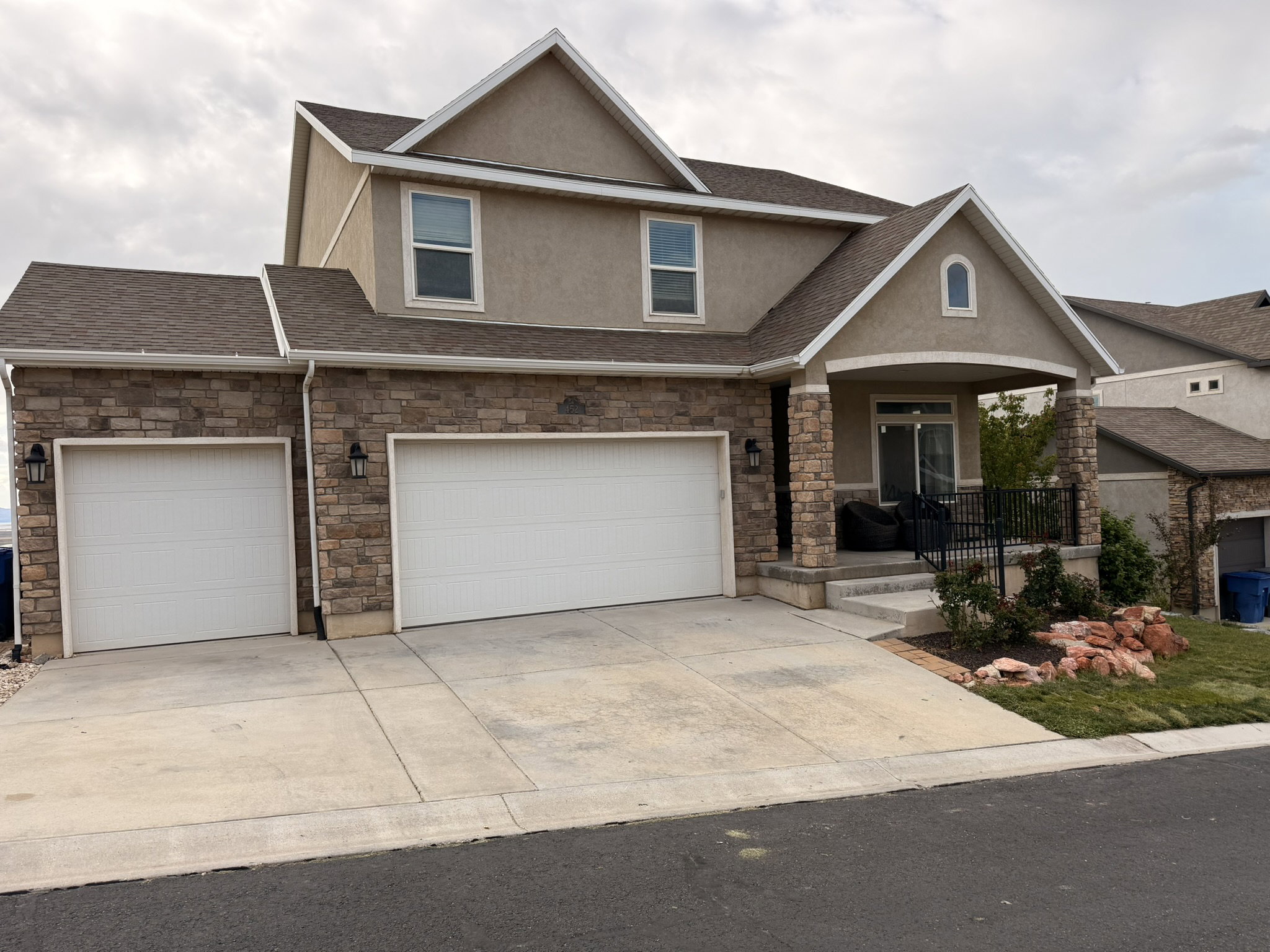 Two-story residence featuring a stone and stucco exterior
