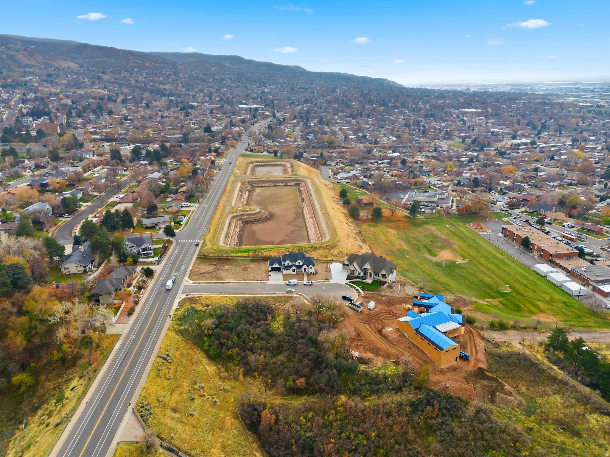 Aerial perspective showcasing a developing residential area with established homes, new construction, and infrastructure