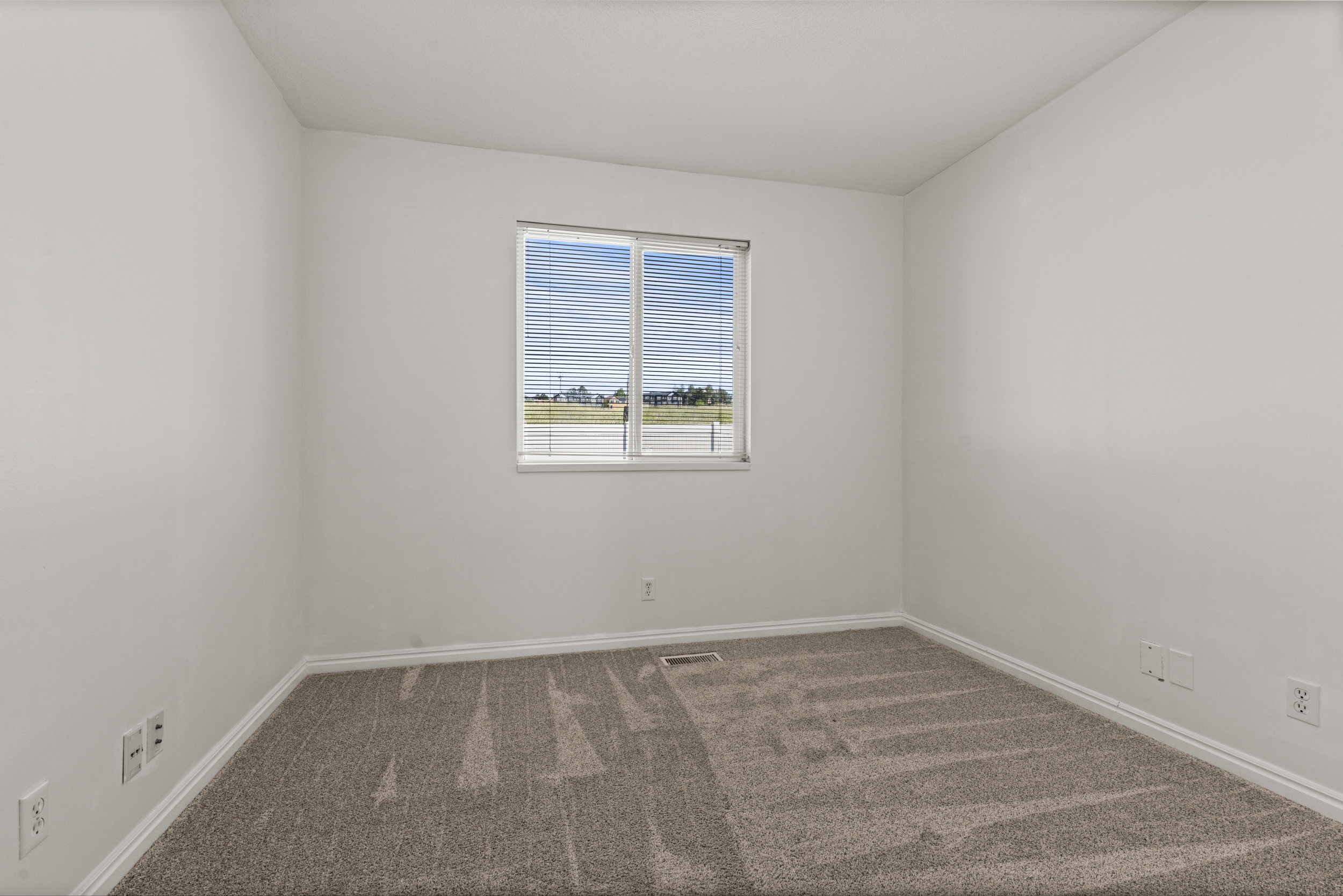 Neutral wall paint with textured carpet flooring