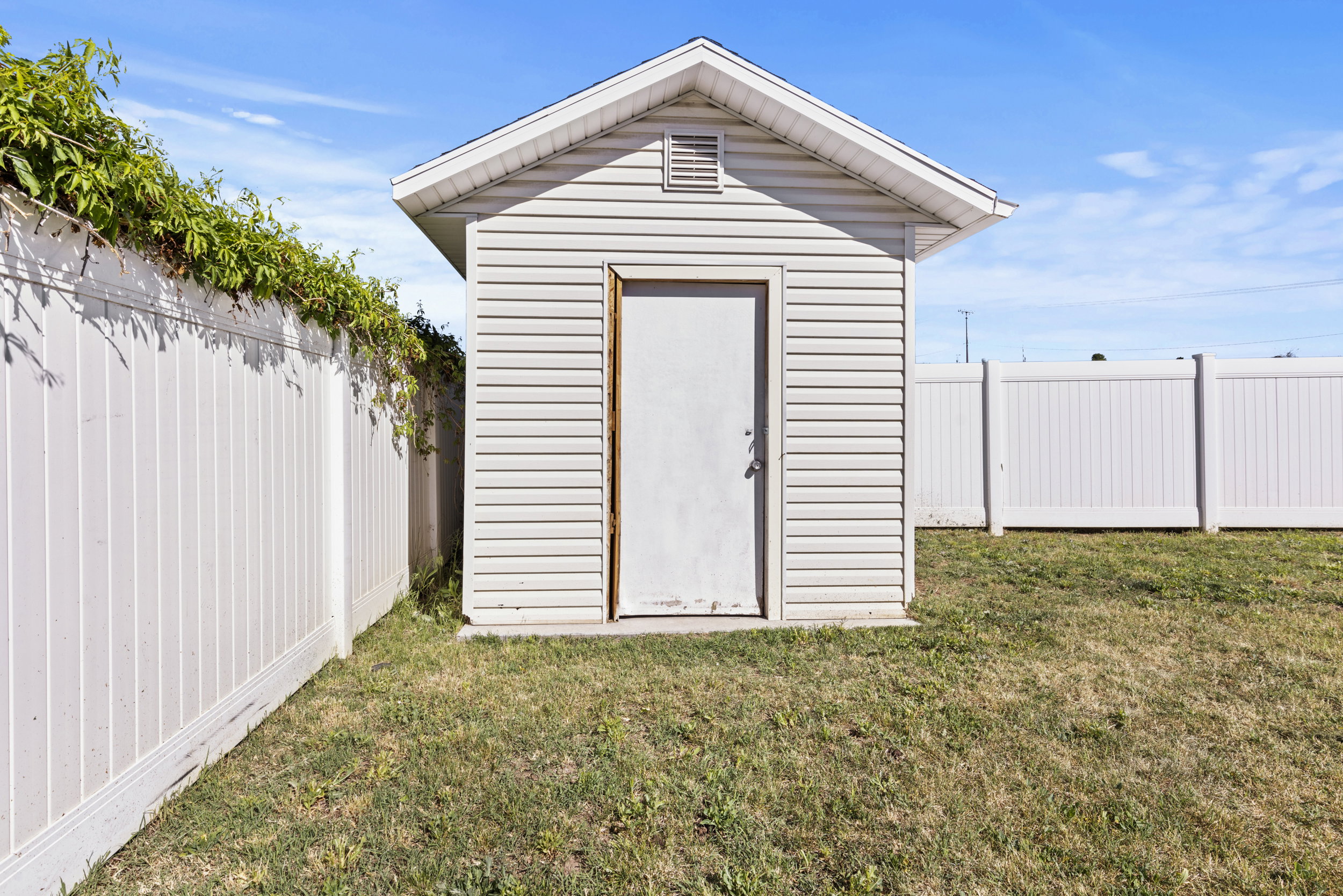 Detached storage shed with vinyl siding and a gable roof