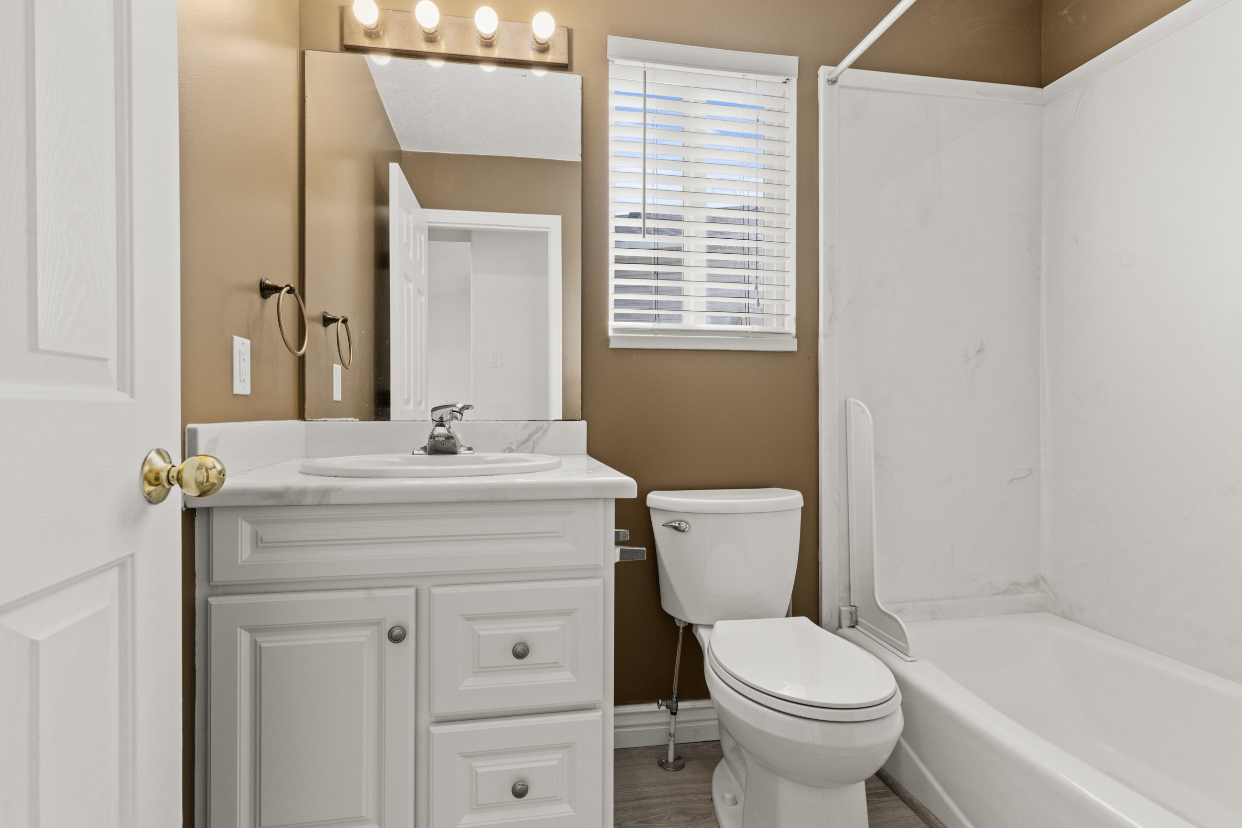 Bathroom featuring a white vanity with panel cabinetry and a white countertop