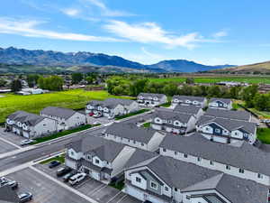 New construction townhomes featuring varied exterior finishes, attached garages, and a paved streetscape