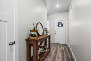 Entryway featuring wood-finish flooring, recessed lighting, and a paneled front door with a window insert