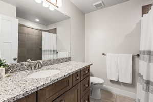 Bathroom featuring a granite countertop vanity with an undermount sink and a brushed nickel faucet