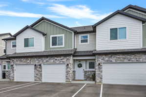 Modern townhouse exterior featuring stone veneer and vertical siding accents