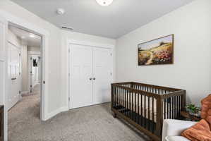 Plush carpeted flooring anchors this interior space featuring light-toned walls and crisp white trim