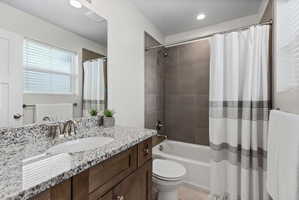 Bathroom featuring a dark wood-finish vanity with a granite countertop, undermount sink, and brushed nickel faucet