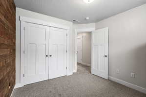 Bedroom featuring a wood accent wall, white paneled doors, neutral gray carpet, and light gray wall paint