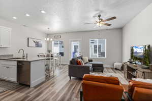 Open-concept living area with wood-finish flooring, recessed lighting, and a ceiling fan