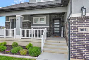 Contemporary exterior featuring dark brick accents and light stucco siding