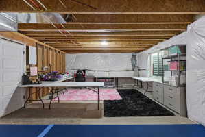 Unfinished basement with exposed wooden joists and ductwork