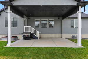 Expansive covered patio featuring a concrete surface, white support columns, and recessed lighting