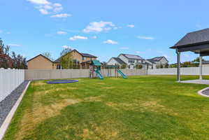 Expansive backyard featuring a covered patio, full perimeter fencing, and a gravel border