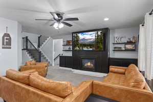 Living area featuring a floor-to-ceiling accent wall with an integrated fireplace and television space