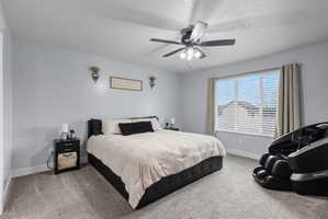 Spacious room featuring light gray walls, plush gray carpeting, a multi-pane window with blinds, a ceiling fan with integrated lighting, and white baseboards