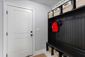 White paneled door with black hardware, complemented by an adjacent built-in black storage bench