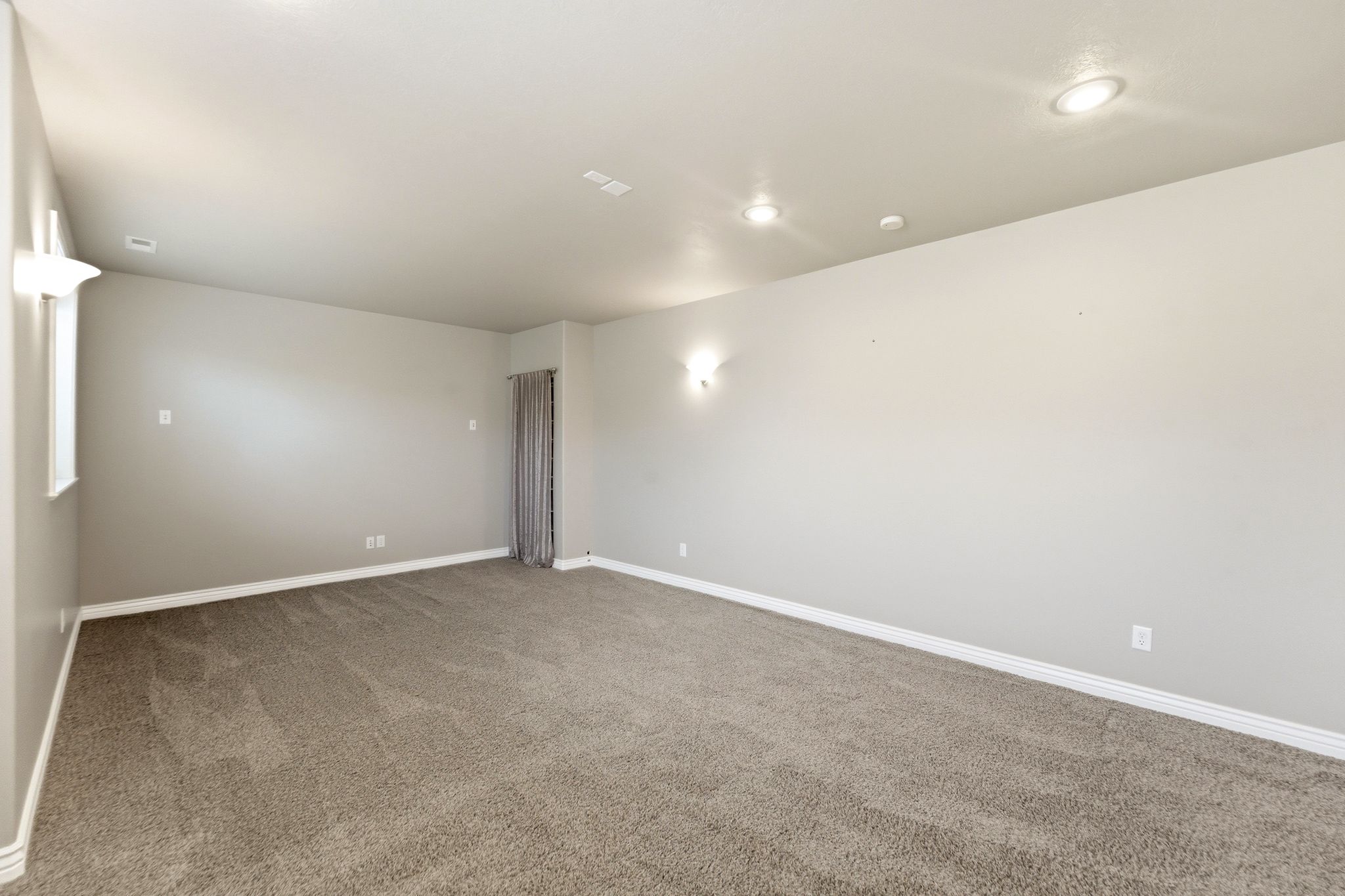 Spacious room featuring neutral carpeting and light gray walls